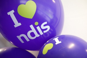 A close-up of three purple I love NDIS balloons