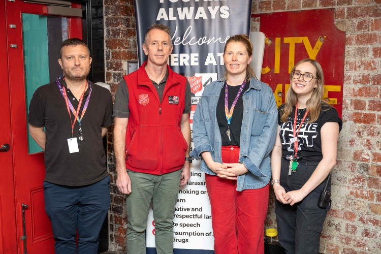 Four collaborators of The Salvation Army Project 614 Café standing together and smiling.