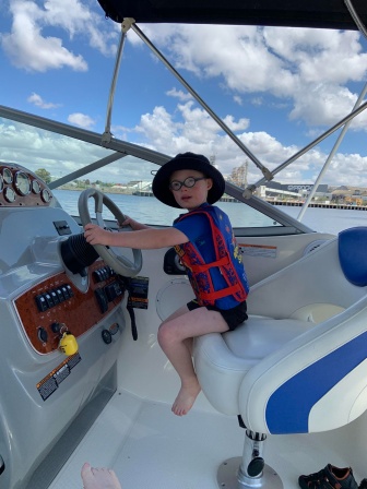 William sits in the captains seat on his parents boat