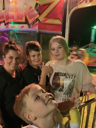 A smiling Tamina with daughter Zahra and sons Chase and Cohen at an amusement park