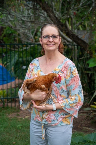 Michelle Owens outside holding a chicken 