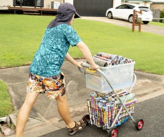 Josh pushes a trolley of advertising materials he is delivering to homes in the neighbourhood