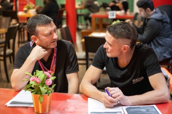 An NDIA planner and a participant talking in with The Salvation Army Project 614 Café.