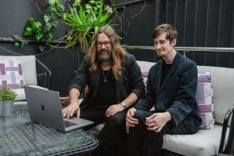 John Holdcroft and Jack Dalton sitting together looking at a laptop 