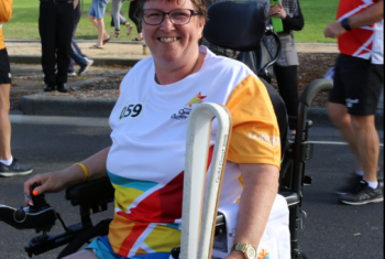 NDIS participant Lynne Foreman holding the Queen's Commonwealth Games baton.