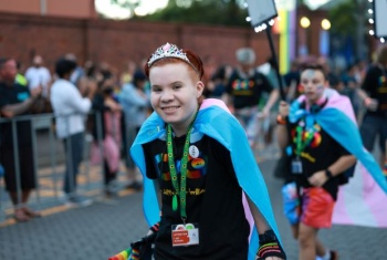 Aspen in a parade wearing crown and cape smiling 