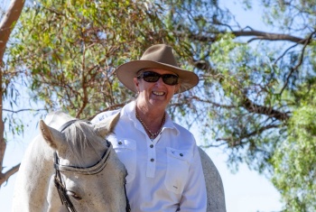 Sue standing with her horses and dog