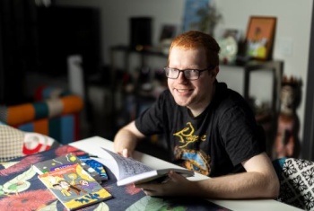 Liam at a desk with his books